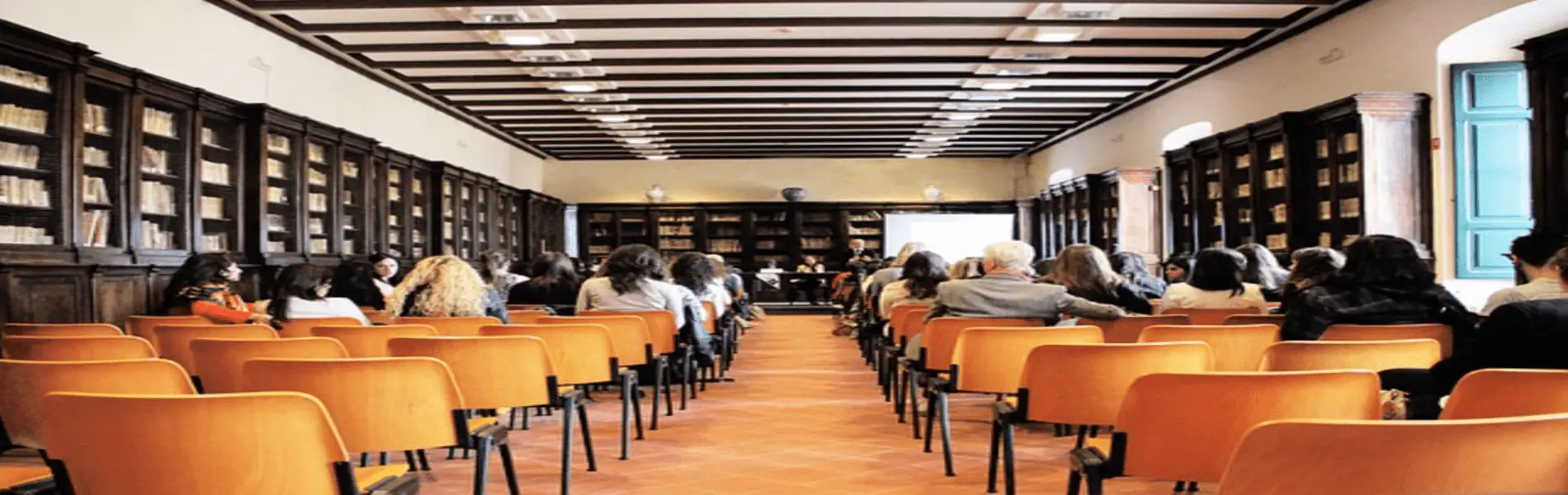 People in a conference room listening to a speaker.